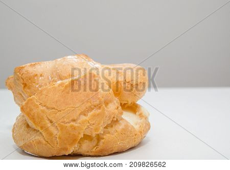 Profiteroles stuffed with pastry cream on white desk in cafe