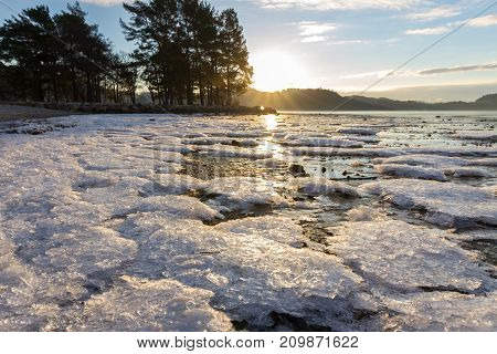 Ice crystals at the beach in winter, sun and reflections of sun in the ice, Hamresanden Norway