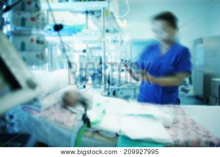 Female doctor working with comatose baby in the intensive care unit.