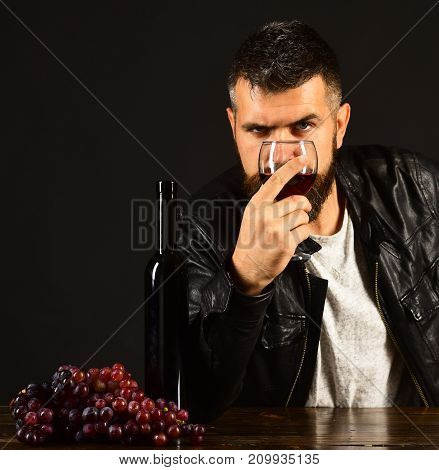 Man With Beard Holds Glass Of Wine On Brown Background