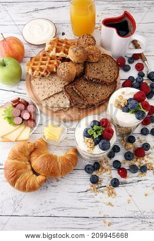 Breakfast served with coffee orange juice bread parfaits and fruits. Balanced diet