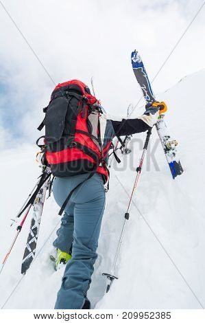 Skiiers climbing a steep slope. Back-country skiing in the mountains.