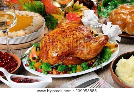 Baked turkey with vegetables pumpkin pie mashed potatoes garlic buns and cranberry-orange sauce on the table dinner on Thanksgiving Day