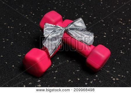 Small dumbbells red for fitness on a black background of the floor