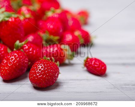Fresh ripe fruits on a gray wooden table. Sweety red strawberries summer fruits on a gray background. Copy space. Close-up of strawberry. Food concept.