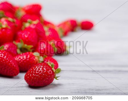 Fresh ripe fruits on a gray wooden table. Sweety red strawberries summer fruits on a gray background. Copy space. Close-up of strawberry. Food concept.