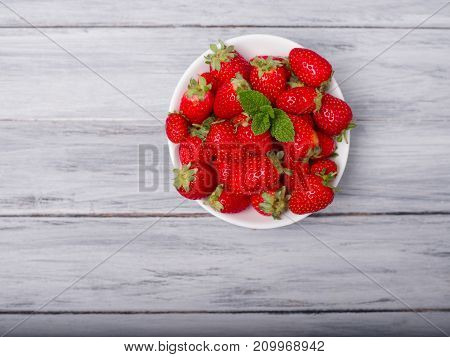 Fresh ripe fruits on a gray wooden table. Sweety red strawberries summer fruits on a gray background. Close-up of strawberry. Food concept.