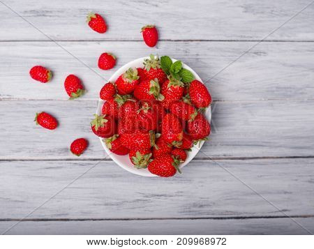Fresh ripe fruits on a gray wooden table. Sweety red strawberries summer fruits on a gray background. Close-up of strawberry. Food concept.