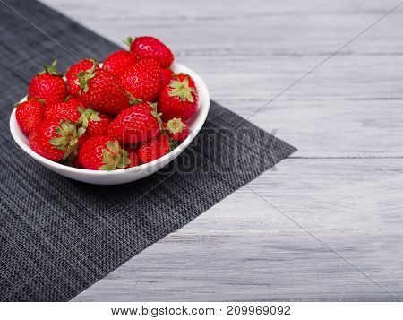 Fresh ripe fruits on a gray wooden table. Sweety red strawberries summer fruits on a gray background. Close-up of strawberry. Food concept.