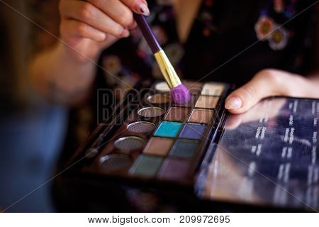 Cosmetic beauty procedures and makeover concept. Woman holds makeup professional palette. Make-up applying