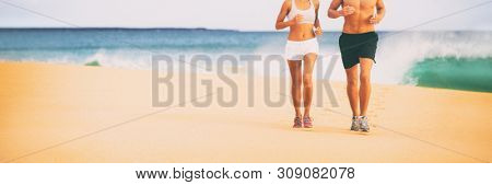 Sports athletes runners couple training together jogging on beack banner background panoramic with copyspace on sand. Two healthy body, woman and man.