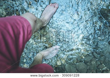 Hiking Outdoors In The Forest: Cut Out Of Male Barefoot Feet In A Shallow River, Fresh Water