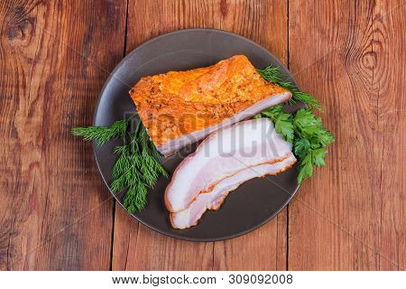 Partly Sliced Boiled Smoked Pork Belly With Skin On The Brown Dish With Greens On The Wooden Rustic 