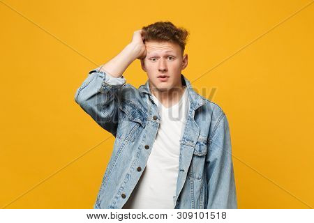 Portrait Of Preoccupied Young Man In Denim Casual Clothes Looking Camera Putting Hand On Head Isolat