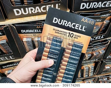 Montreal, Canada - June 20, 2019: A Hand Holding Duracell Batteries Pack Over A Shelf. Duracell Is A