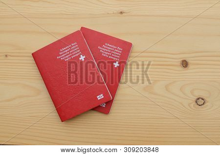 Top View Of Two Swiss Passports On A Wooden Table