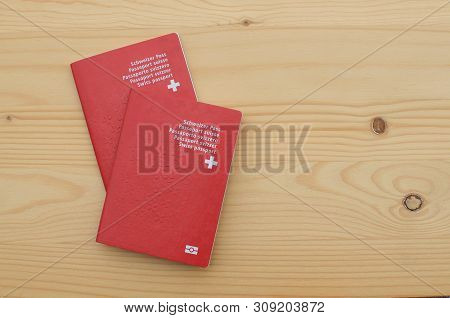 Top View Of Two Swiss Passports On A Wooden Table