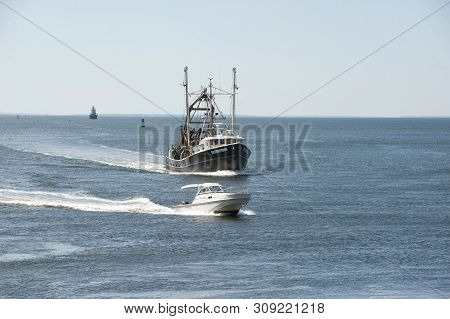 New Bedford, Massachusetts, Usa - July 1, 2019: Powerboat Scoots Around Clammer Enterprise, Hailing 