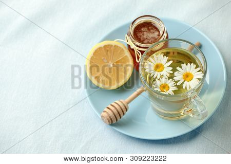 Chamomile Flowers And Chamomile Tea. Chamomile Tea In Glass Teacup With Flowers, Honey And Lemon, To