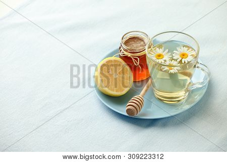 Chamomile Flowers And Chamomile Tea. Chamomile Tea In Glass Teacup With Flowers, Honey And Lemon, To