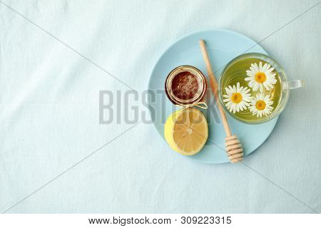 Chamomile Flowers And Chamomile Tea. Chamomile Tea In Glass Teacup With Flowers, Honey And Lemon, To