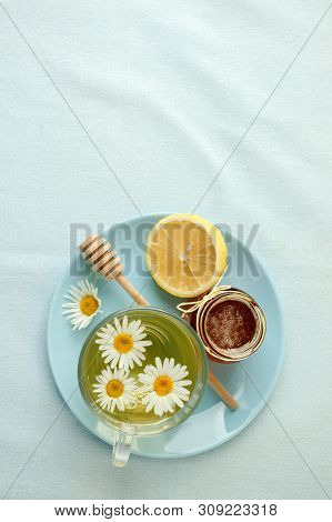Chamomile Flowers And Chamomile Tea. Chamomile Tea In Glass Teacup With Flowers, Honey And Lemon, To