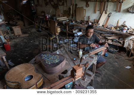 Gianyar,bali/indonesia-may 30 2019: A Guitar Craftsman Is Measuring And Make Sure It Is A Precision