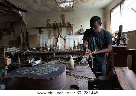 Gianyar,bali/indonesia-may 30 2019: A Guitar Craftsman Is Measuring And Make Sure It Is A Precision
