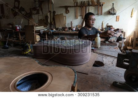 Gianyar,bali/indonesia-may 30 2019: A Guitar Craftsman Is Measuring And Make Sure It Is A Precision
