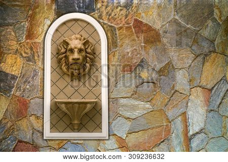 Lion Head Statue On Cavernous Stone Wall. Concept Decoration Architecture Sculpture Low Relief Ornam