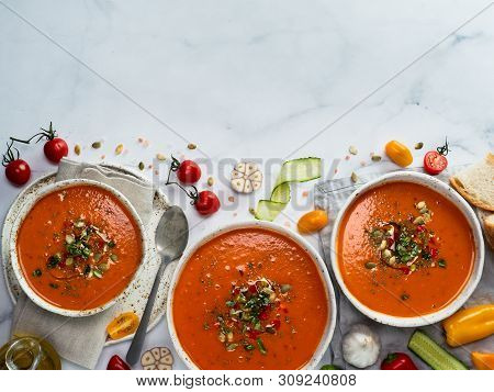 Gaspacho Soup On White Marble Tabletop. Three Bowls Of Traditional Spanish Cold Soup Puree Gaspacho 