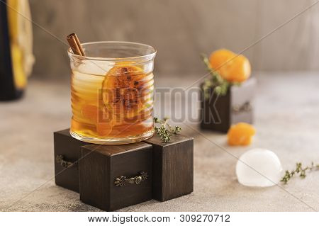 Whiskey Sour Cocktail With Tangerine Slices And Ice Cubes Decorated With Cinnamon And Thyme. Alcohol