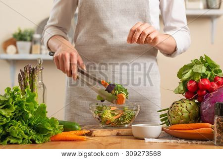 Chef Salting Fresh And Bright Salad Close-up, On A Light Background. The Concept Of Losing Healthy A