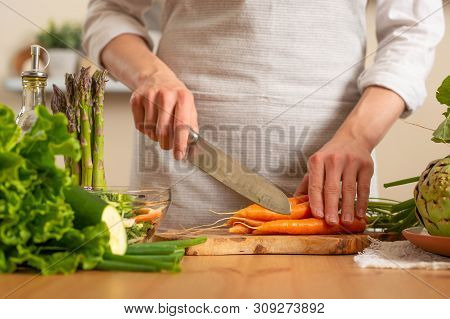 The Chef Cuts Fresh Carrots For Salad. The Concept Of Losing Healthy And Wholesome Food, Detox, Vega