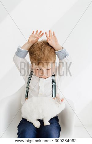 Adorable Little Boy Playing With Rabbit Portrait. Funny Ginger Kid Holding Decorative Bunny In Lap I