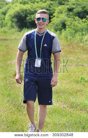 Brusilov, Ukraine - July 17, 2017: A Sporty Guy In Adidas Clothes Is Walking Along The Field. Traine