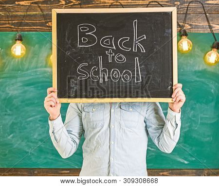 Start Of School Year Concept. Teacher Faceless Holds Blackboard With Title Back To School. Man Welco