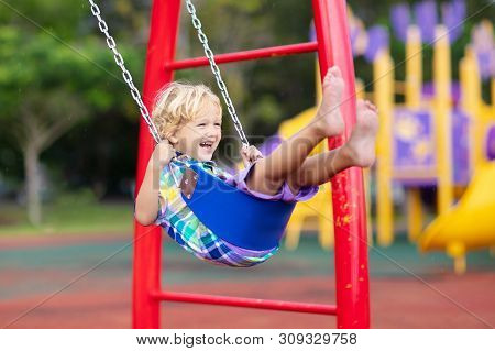 Child On Playground. Swing Kids Play Outdoor.