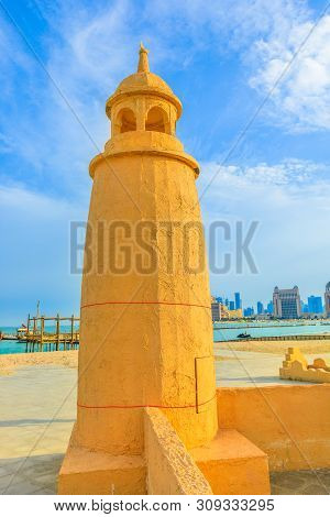 Katara Beach Lighthouse With Wooden Boats And West Bay Skyline On Background In Doha Bay Area Near K