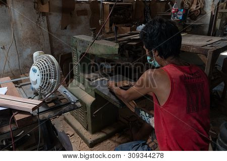 Gianyar,bali/indonesia-may 30 2019: A Guitar Craftsman Is Cutting To Make Sure His Guitar Precision