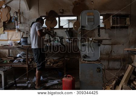 Gianyar,bali/indonesia-may 30 2019: A Guitar Craftsman Is Measuring And Make Sure It Is Precision In