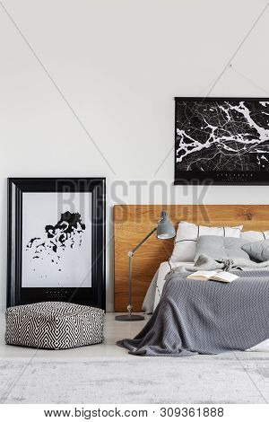 Black Map On White Wall Above Wooden Headboard In Simple Bedroom Interior