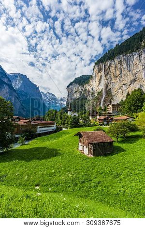 Famous View Of Lauterbrunnen Town In Swiss Alps Valley With Gorgeous Staubbach Waterfalls In The Bac