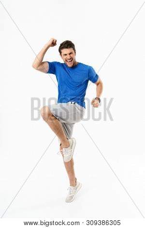 Image of excited handsome happy young sports fitness man standing isolated over white wall background make winner gesture.