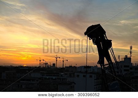 Crane In Metro City With Sunrise Background