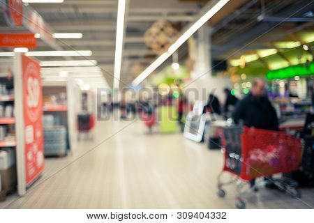 Blurred Brightly Background Of The Supermarket. Cashier, Gueues At The Store. Sale Time Concept.