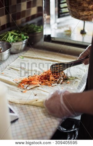Cooking Fajitos In The Cafe. Cooking Shawarma In Pita In The Kitchen. Wrap Chicken, Carrots, Lettuce