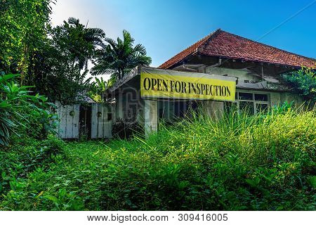 Open For Inspection Plastic Sign Banner In Front Of Empty Damage Abandoned House Building With Unatt