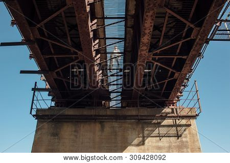 Bluesman With Guitar Case Walks On Railroad Bridge. Silhouette Of Blues Musician On Rusty Railway Br