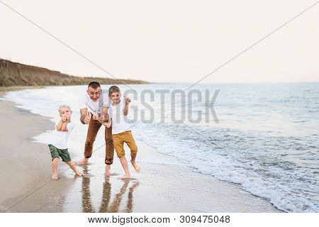 Father And Two Sons Show Class, Sea Coast. Enjoying Vacation